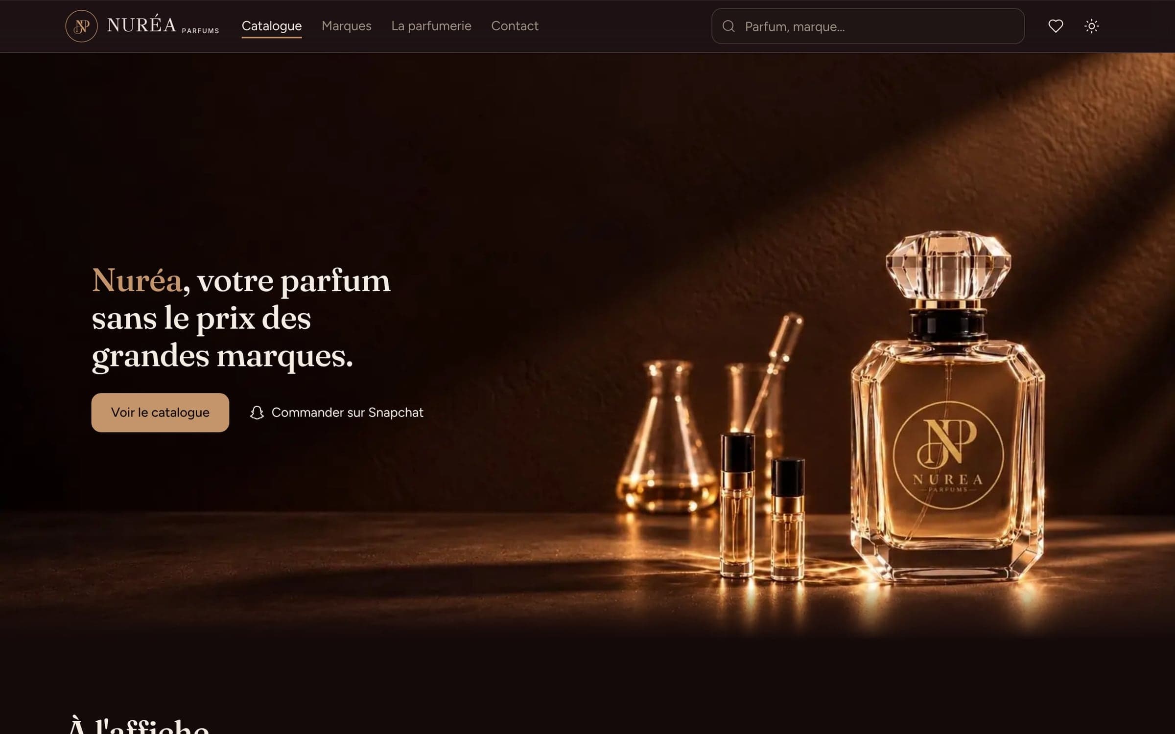 L’accueil sombre de Nuréa Parfums : la barre de recherche, le titre « Nuréa, votre parfum sans le prix des grandes marques. », les boutons « Voir le catalogue » et « Commander sur Snapchat », et la photographie d’un flacon Nuréa dans une lumière dorée.